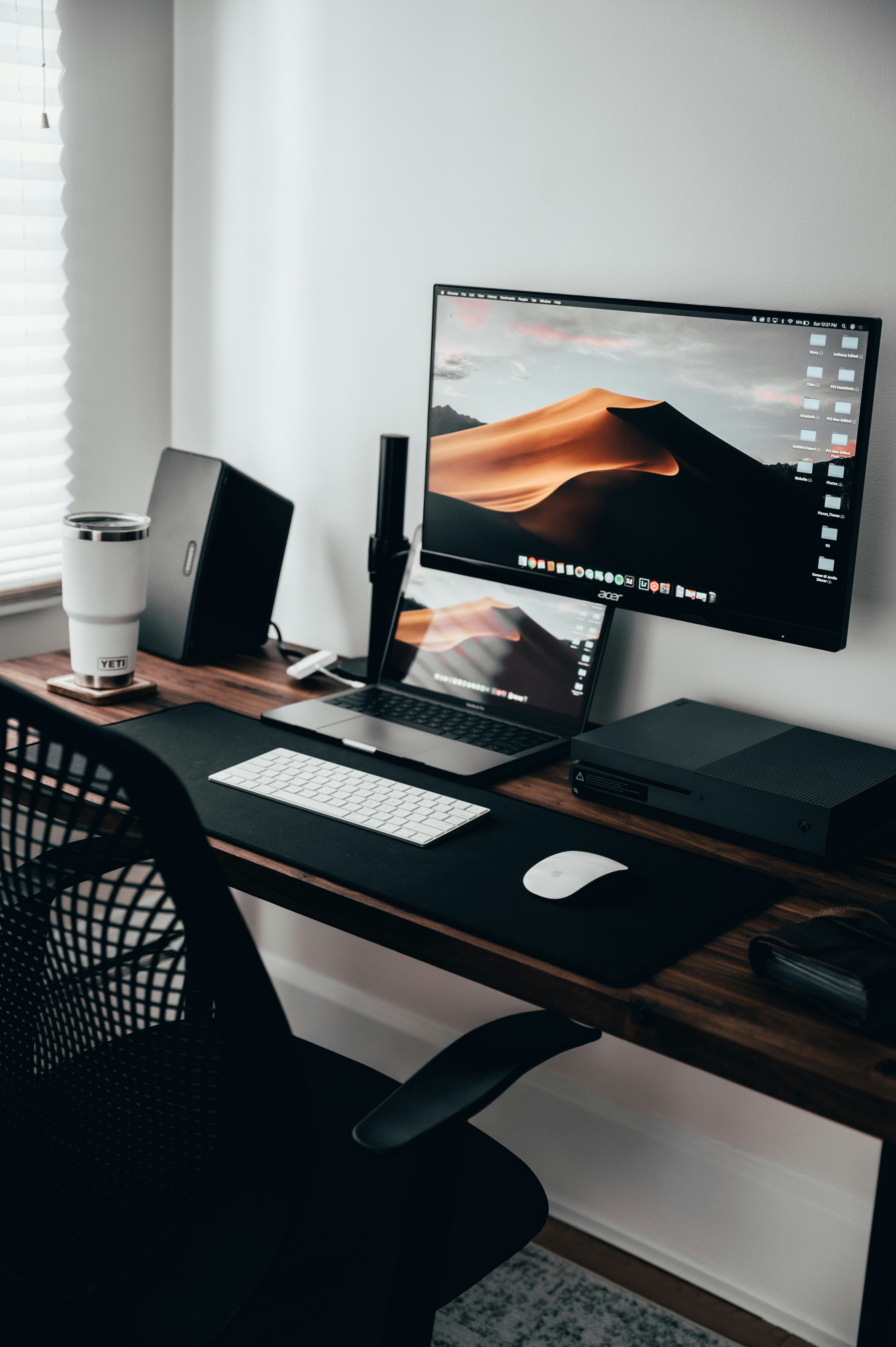 A tidy workspace with a laptop, monitor and keyboard