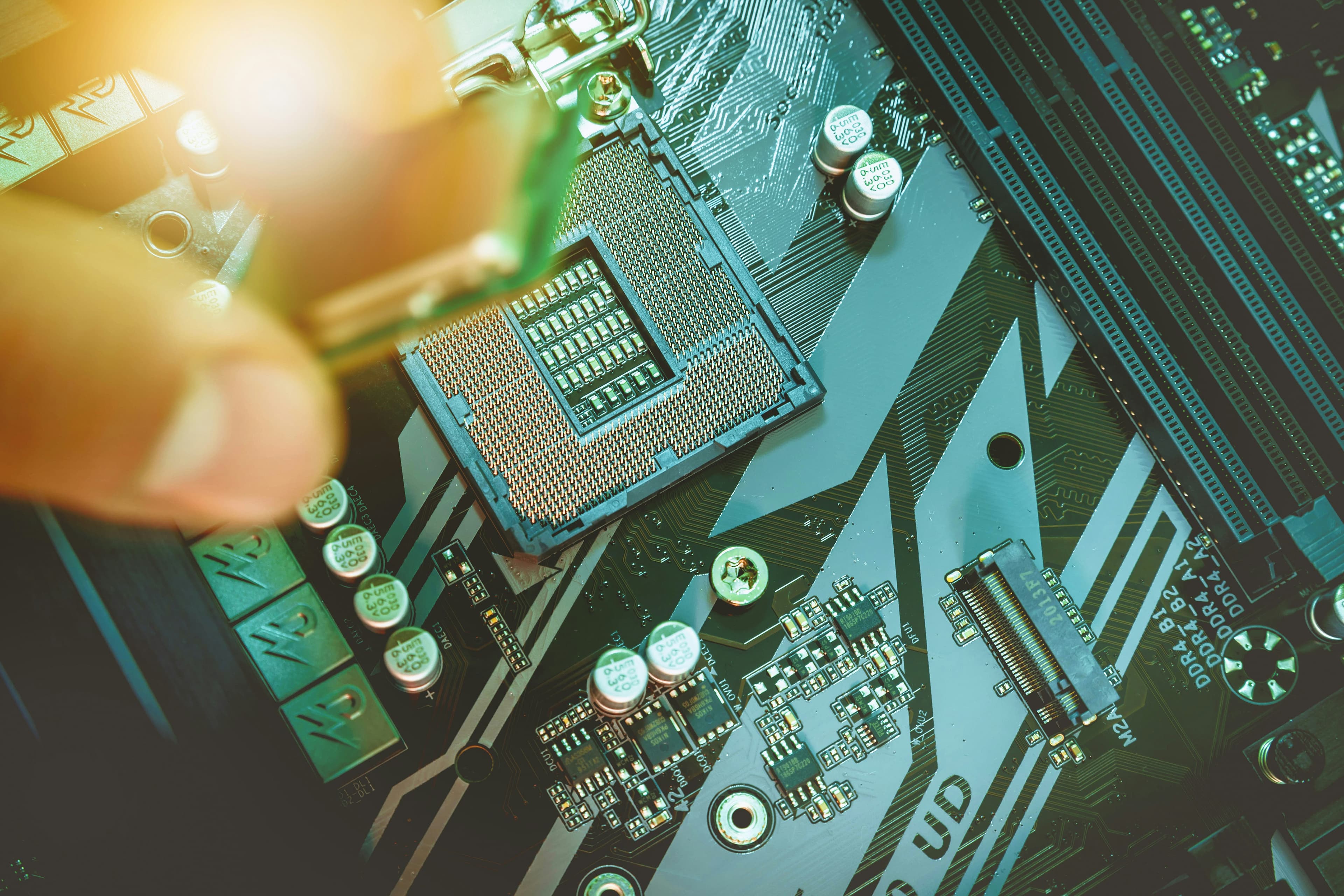 A technician fitting a processor onto a motherboard